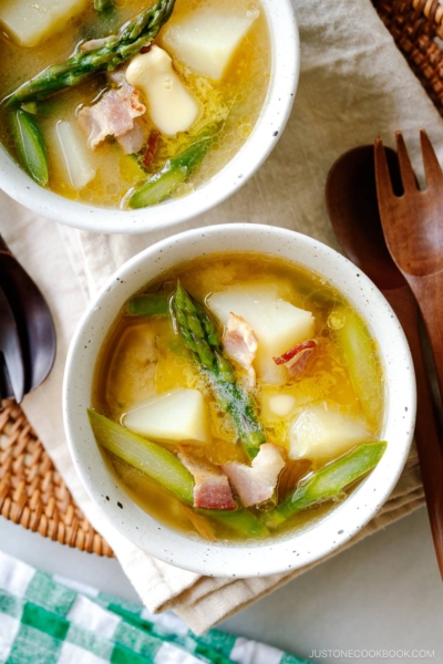 White ceramic bowls containing Bacon Asparagus Miso Soup topped with a slice of butter.