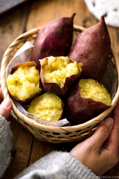 Japanese bamboo basket containing baked sweet potatoes.