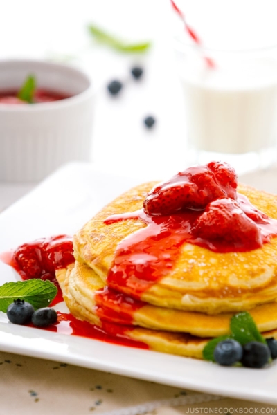 A dish containing Buttermilk Pancakes with strawberry compote.