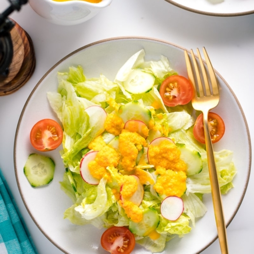 Carrot ginger dressing drizzled on the refreshing iceberg lettuce and cucumber slices.