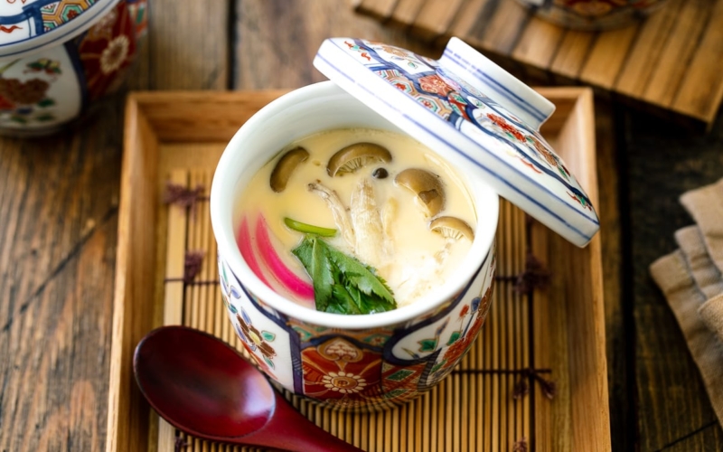 A special Japanese chawanmushi cup containing savory steamed custard filled with kamaboko fish cake, chicken, and mushroom.