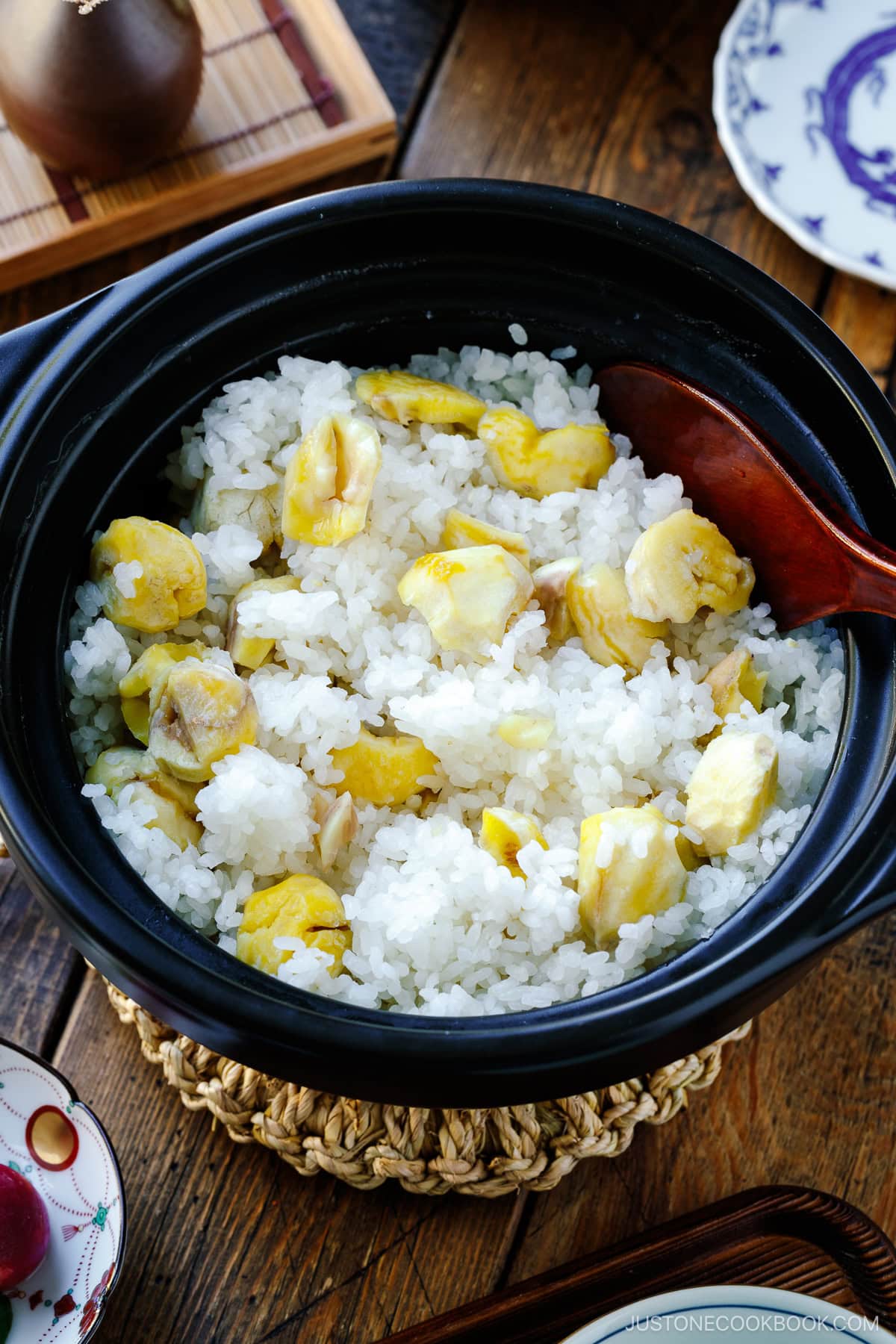 A ceramic donabe bowl containing Japanese chestnut rice (kuri gohan) mixed with a rice puddle.