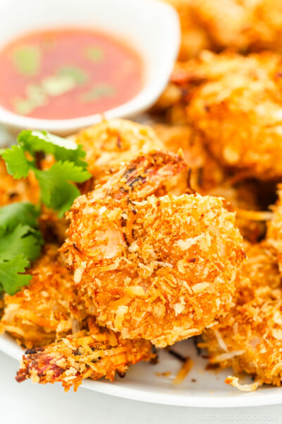 Coconut shrimp with sauce on a white plate.