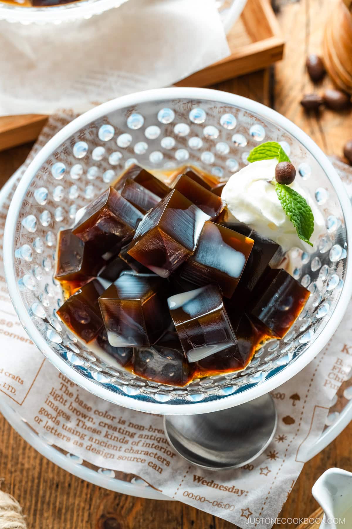 Glass bowls containing Coffee Jelly, drizzled with cream and topped with fresh whipped cream.