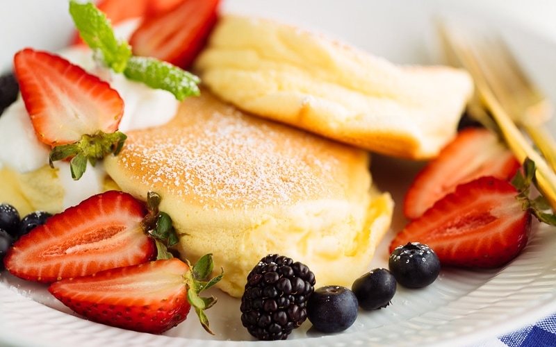 A white plate containing fluffy Japanese souffle pancakes.