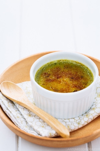 Green tea creme brulee in a white ramekin.