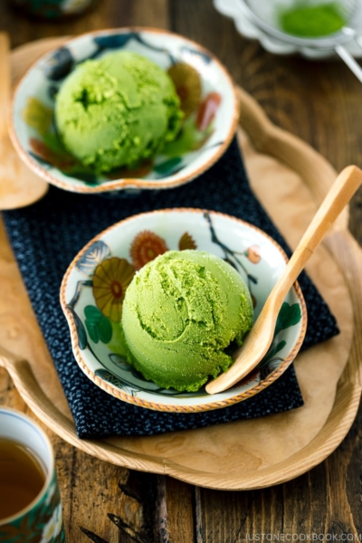 A Japanese kutaniware bowl containing matcha green tea ice cream served with wooden spoon.