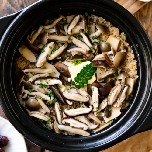 A Hario donabe (Japanese clay pot) containing Japanese Mushroom Rice topped with butter, chives, and sea salt flakes.