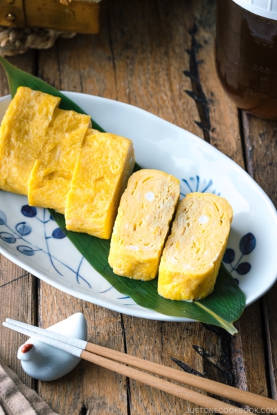 An oval plate containing Japanese sweet rolled omelet.