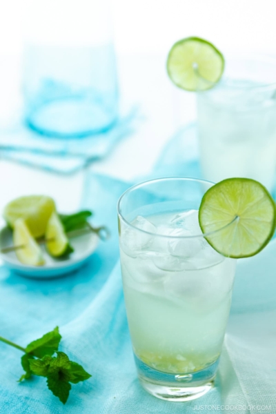 A glass filled with Japanese Yuzu Cocktail (Yuzu Chuhai) garnished with a slice of lime.