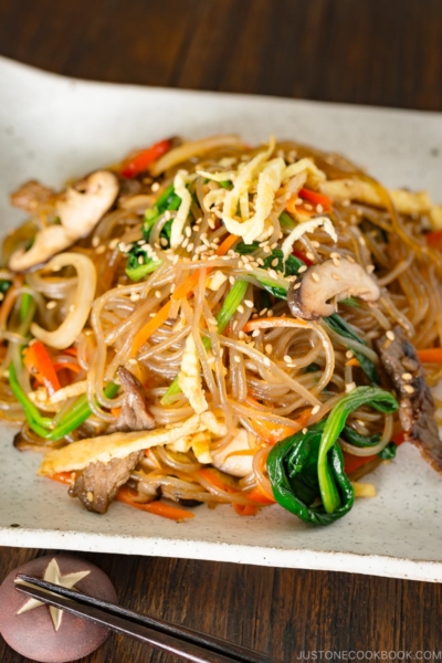 A white square plate containing Japchae (Korean Stir-Fried Noodles)