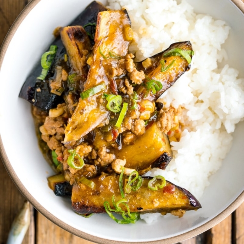 A white bowl containing Mapo Eggplant (Mabo Nasu) served over steamed rice.