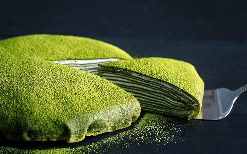 Matcha Mille Crepe Cake served on a black board.