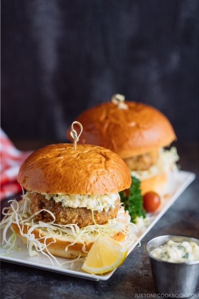 Menchi Katsu Sandwich is a ground meat patty coated with crispy panko and deep fried into golden brown. It is then topped with thinly sliced cabbage and homemade tartar sauce, and sandwiched in soft brioche buns.