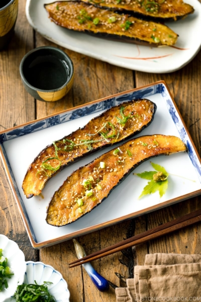 A square plate containing Miso Glazed Eggplant garnished with yuzu kosho.