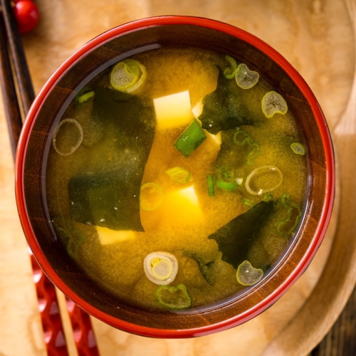 Japanese miso soup bowls containing tofu and wakame miso soup.