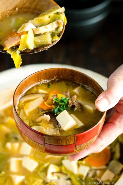 Miso soup served into a soup bowl from a donabe clay pot.