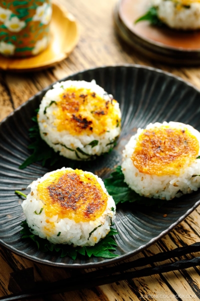 Miso Yaki Onigiri placed on a bizenware ceramic plate garnished with shiso leaf.