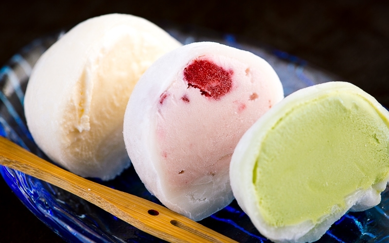 Vanilla, strawberry, and matcha mochi ice cream served on a glass plate.