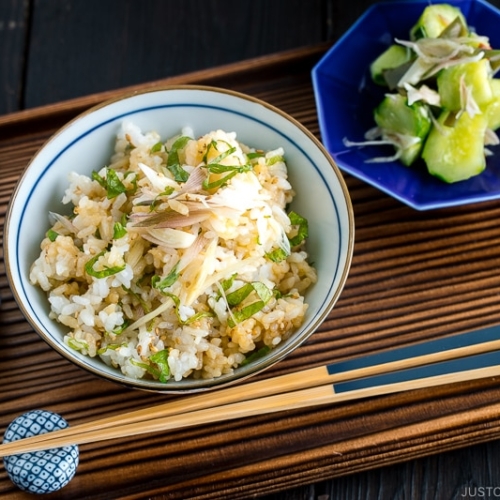 A Japanese rice bowl containing Myoga Shiso Rice (Mazegohan) served with pickled cucumber.