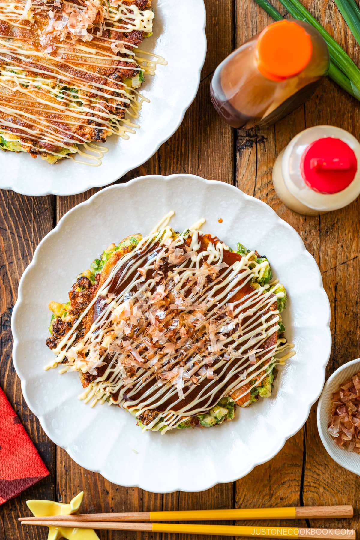 White scalloped plates containing negiyaki, a savory Japanese scallion pancake.