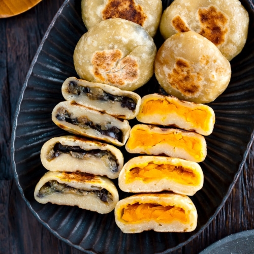 A dark plate containing Kabocha and Eggplant Oyaki (Japanese Stuffed Dumplings).