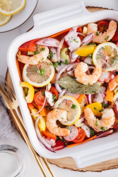 Seafood salad with vinaigrette in the white baking dish.