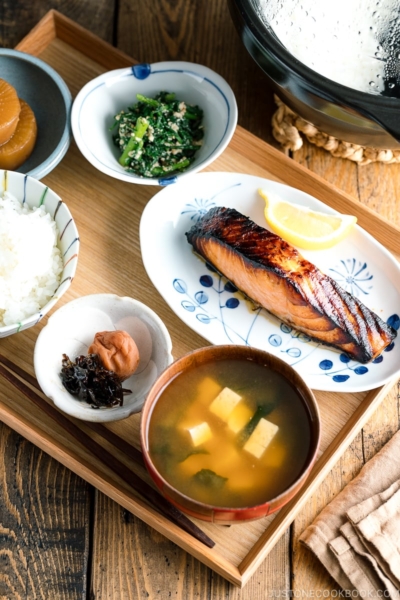 A Japanese meal set with shio koji salmon, miso soup, rice, and side dishes.