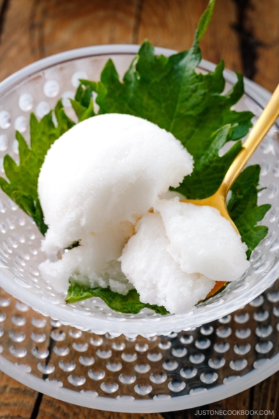 A white glass bowl containing Shiso Sorbet garnished with shiso leaf.