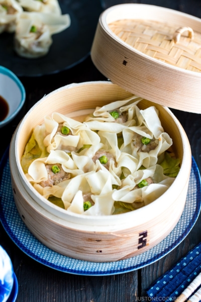 A bamboo steamed basket containing pork shumai (steamed pork dumplings).