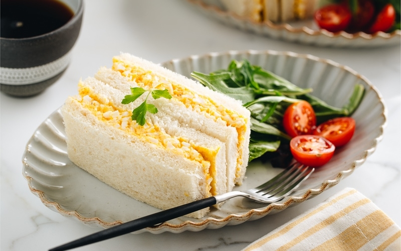 Tamago Sando - Japanese Egg Salad Sandwich on a plate along with salad.