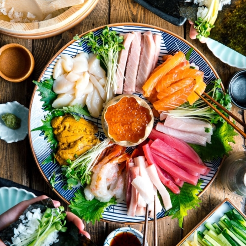 A sashimi platter with varioius sashimi (tuna, salmon, amaebi, uni, scallop, kanpachi, ikura and more), sushi rice, and vegetable platter.