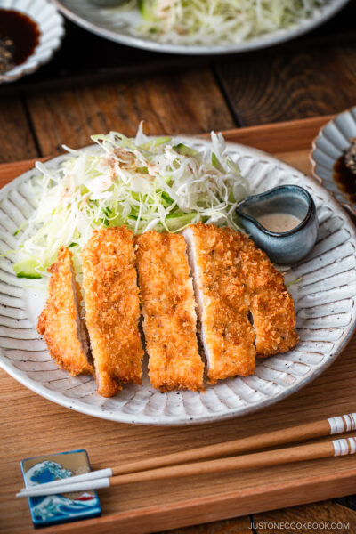 Japanese ceramic plates containing Tonkatsu (pork cutlet) and shredded cabbage salad.