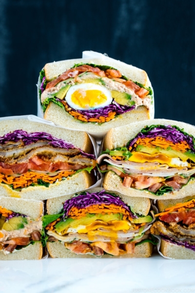 Colorful thick Japanese sandwich, Wanpaku Sandiwch (Sando), shows the filling and piles up on the table.