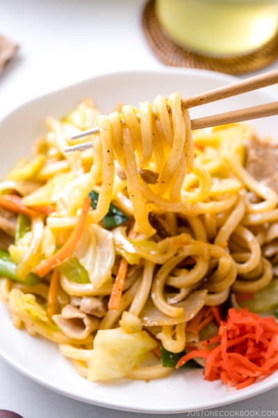 Yaki Udon (Japanese Stir-Fried Udon Noodles) being pulled out with chopsticks.